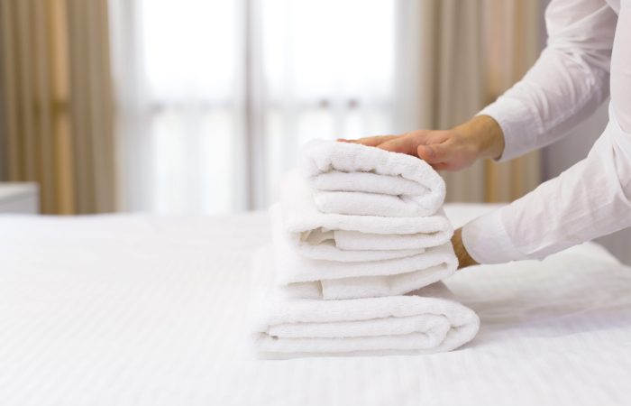 hotel staff setting up pillow on bed